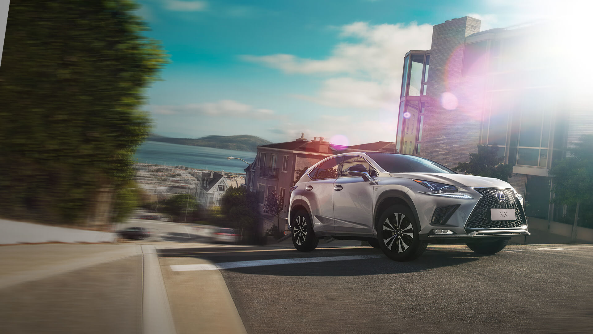 Silver Lexus NX being driven on the road.